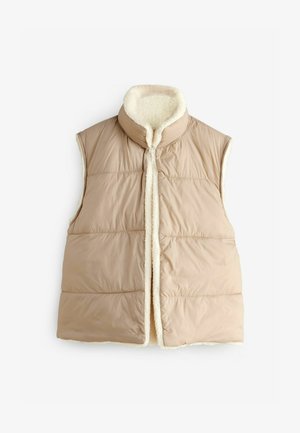 Gilet sans manches isolé beige avec un col haut, doublure crème douce et texture matelassée. Fermeture au centre avant sans matériel visible.
