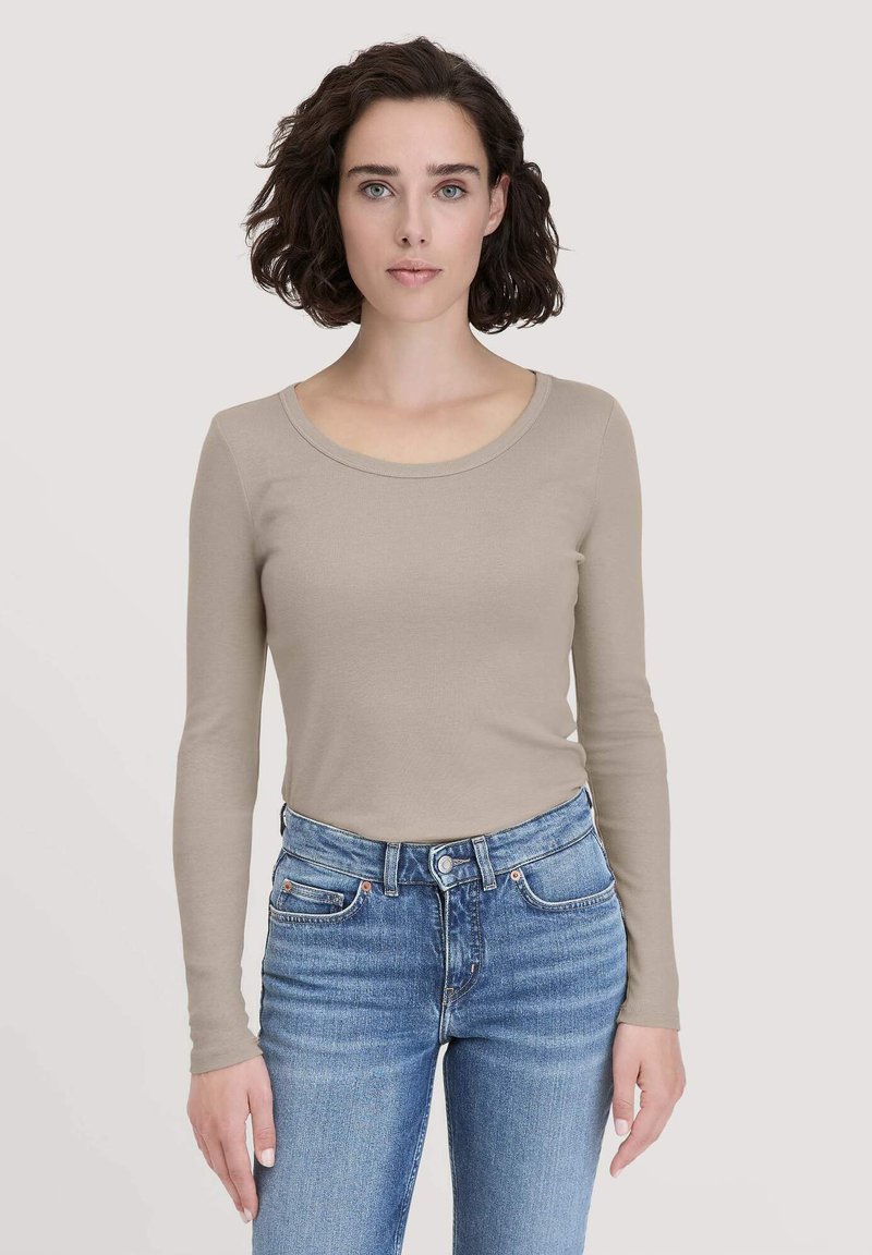 Beige lange mouw top gemaakt van zachte stof, met een ronde halslijn, slim fit, en gecombineerd met hoge blauwe spijkerbroek.
