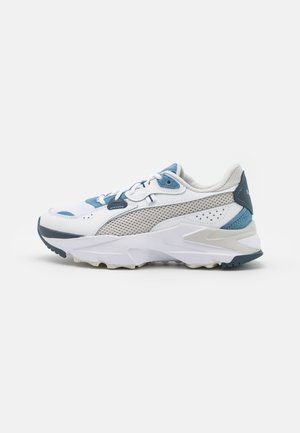 Weißer und grauer Sportschuh mit blauen Akzenten, Mesh-Einsätzen, dicker Sohle und Schnürverschluss, von der Außenseite auf weißem Hintergrund gezeigt.
