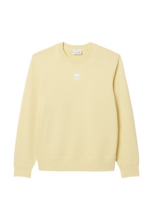 Geel sweatshirt gemaakt van zacht materiaal, met een ronde hals, lange mouwen en een wit Lacoste-logo op de borst. Eenvoudig en niet versierd ontwerp.
