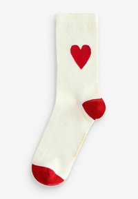 Biała bawełniana skarpetka z czerwonym sercem na froncie, z czerwonymi akcentami na palcach i pięcie. Gładka faktura, prążkowany splot.
