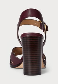 Burgundy bőr szandál széles bokapánttal és fából készült, bordázott tömbsarokkal. Simább belső rész, állítható csat záródással.