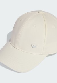 Krémová baseballová čepice s zakřiveným kšiltem a vyšitým bílým logem na přední straně. Vyrobena z texturované tkaniny s ventilačními otvory na koruně.