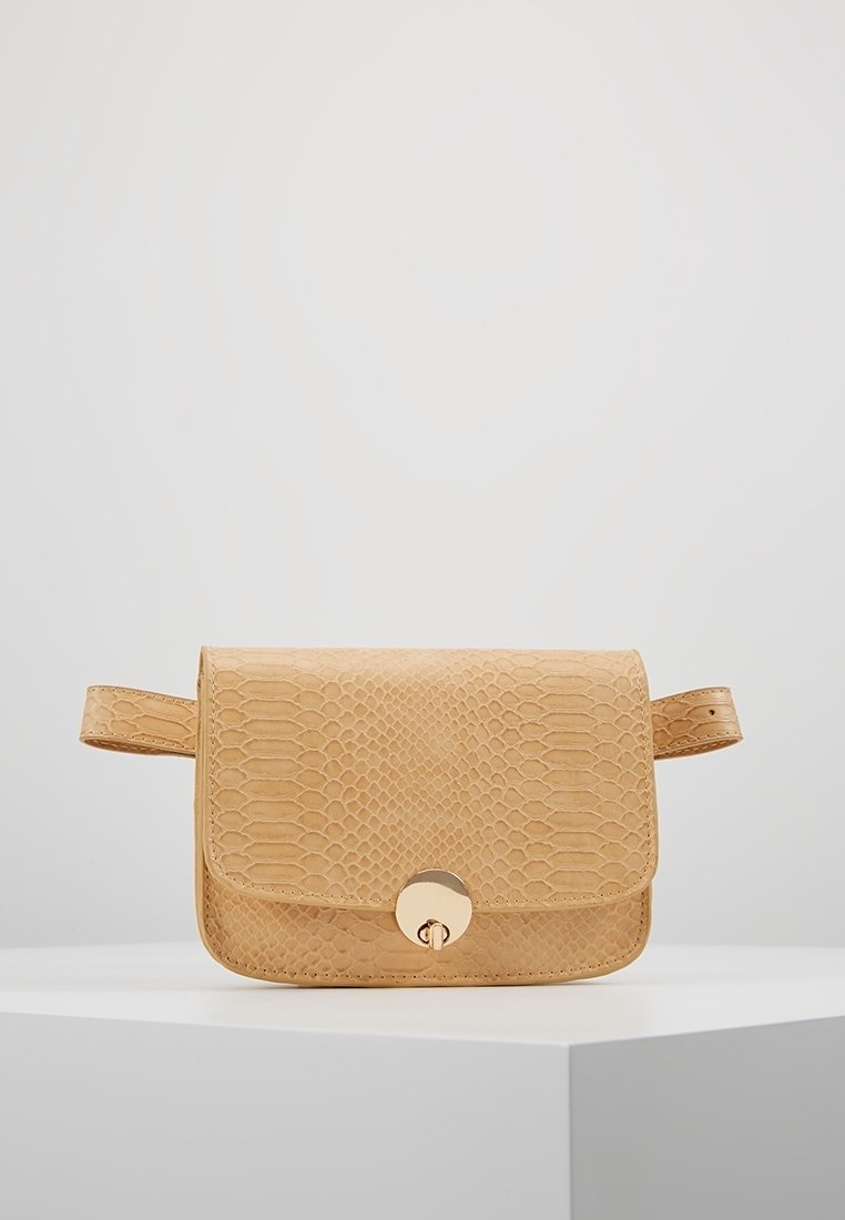 Béžová kabelka s hadím vzorem, obdélníkového tvaru, s magnetickým zapínáním a jedním popruhem. Hladký povrch s kovovými akcenty.
