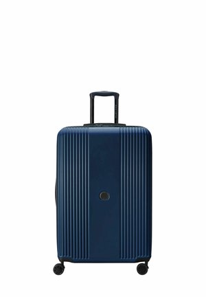 Valigia rigida blu navy con scanalature verticali, manico estraibile, doppie ruote e chiusura centrale con zip. Presenta un logo discreto sul davanti.