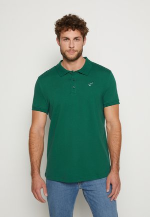 Green polo shirt made of cotton, featuring a collared neckline, three-button placket, and a small logo on the left chest.