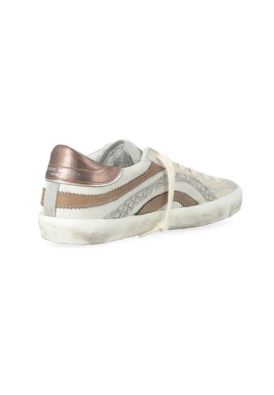 Baskets pour femmes avec une tige en daim beige, des accents en bronze scintillants, des lacets plats et une semelle en caoutchouc blanc légèrement usée.