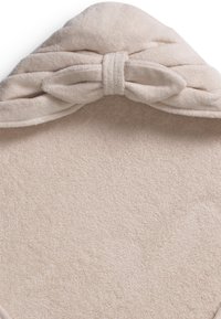 Beige huva handduk med en strukturerad yta och en knuten rosett som accent vid toppen. Mjuk, absorberande material, triangulär i formen.