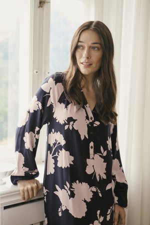 Blumengemustertes Kleid in Marineblau und Pink, mit V-Ausschnitt und Knopfdetails. Lange Ärmel und eine weiche Textur unterstreichen das Design.