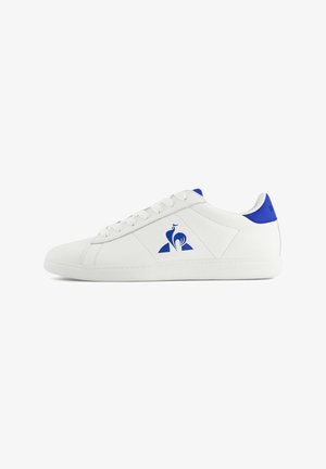 White sneakers with a smooth leather surface, blue accents on the heel and logo. Features a classic lace-up design and textured sole.