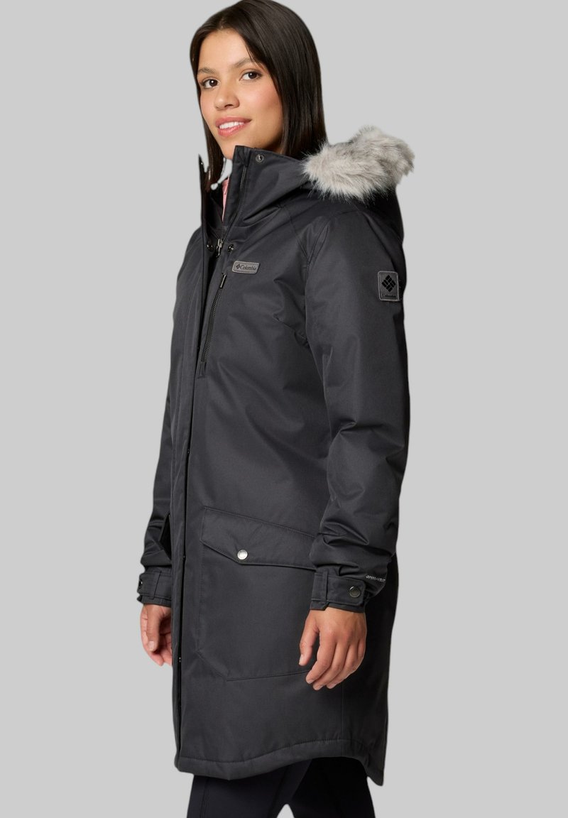 Langer schwarzer wasserdichter Parka mit einer Kapuze mit Kunstfellfutter, Frontreißverschluss und großen Druckknopf-Taschen. Glatte Textur und taillierte Silhouette.