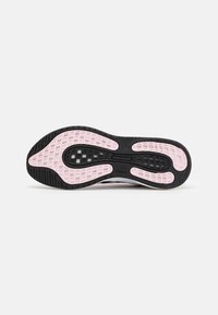 Suela de zapato deportivo negro y rosa con un patrón texturizado con recortes, acabado suave y un logotipo cerca del centro.