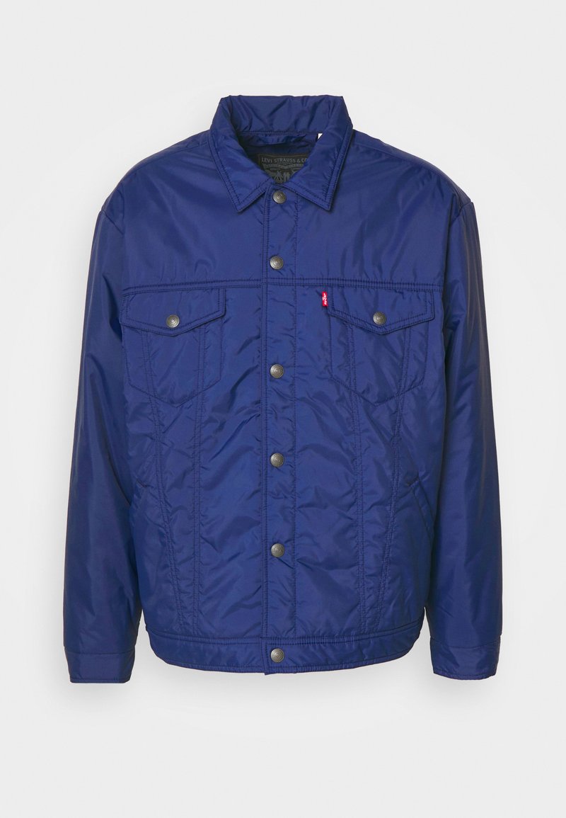 Chaqueta acolchada de color azul marino con botones a presión, dos bolsillos en el pecho y cuello alto. Fabricada con una tela suave y ligera.