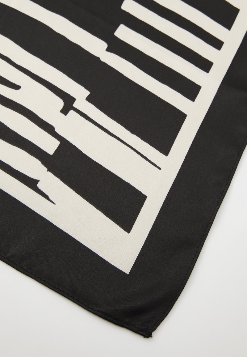 Czarny i biały jedwabny szal z abstrakcyjnym wzorem grubych, nierównych pasków i prostokątnych kształtów o satynowym wykończeniu.