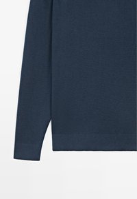 Granatowy sweter z miękkiego dzianinowego materiału, z długimi rękawami, ściągaczami na mankietach oraz prostym, prostym wykończeniem na dole.