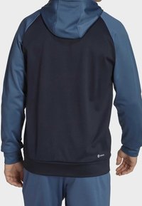Hooded sweatshirt featuring a dark navy body with light blue accents on the sleeves and hood, crafted from soft, breathable fabric.
