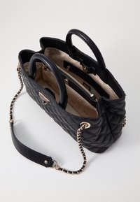 Sort quiltet håndtaske lavet af læder med to top-hanke, en aftagelig kæderem og hardware i guldfarve. Indvendigt har den flere rum.