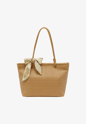 Smėlio spalvos audinė pintinė rankinė su lygiu paviršiumi, kurią puošia dekoratyvi kreminė ir auksinė raštuota kaspinas. Ilgos, derančios odinės rankenos.