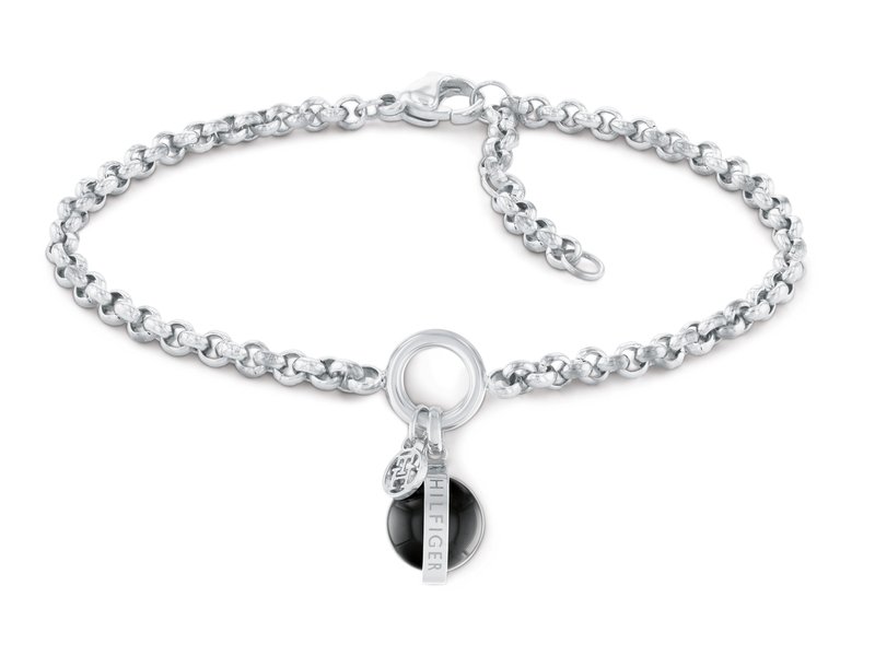 Pulsera de cadena de metal plateado con eslabones redondos, que cuenta con un cierre de anillo y un charm negro con una etiqueta de logo. Textura suave, acabado pulido.