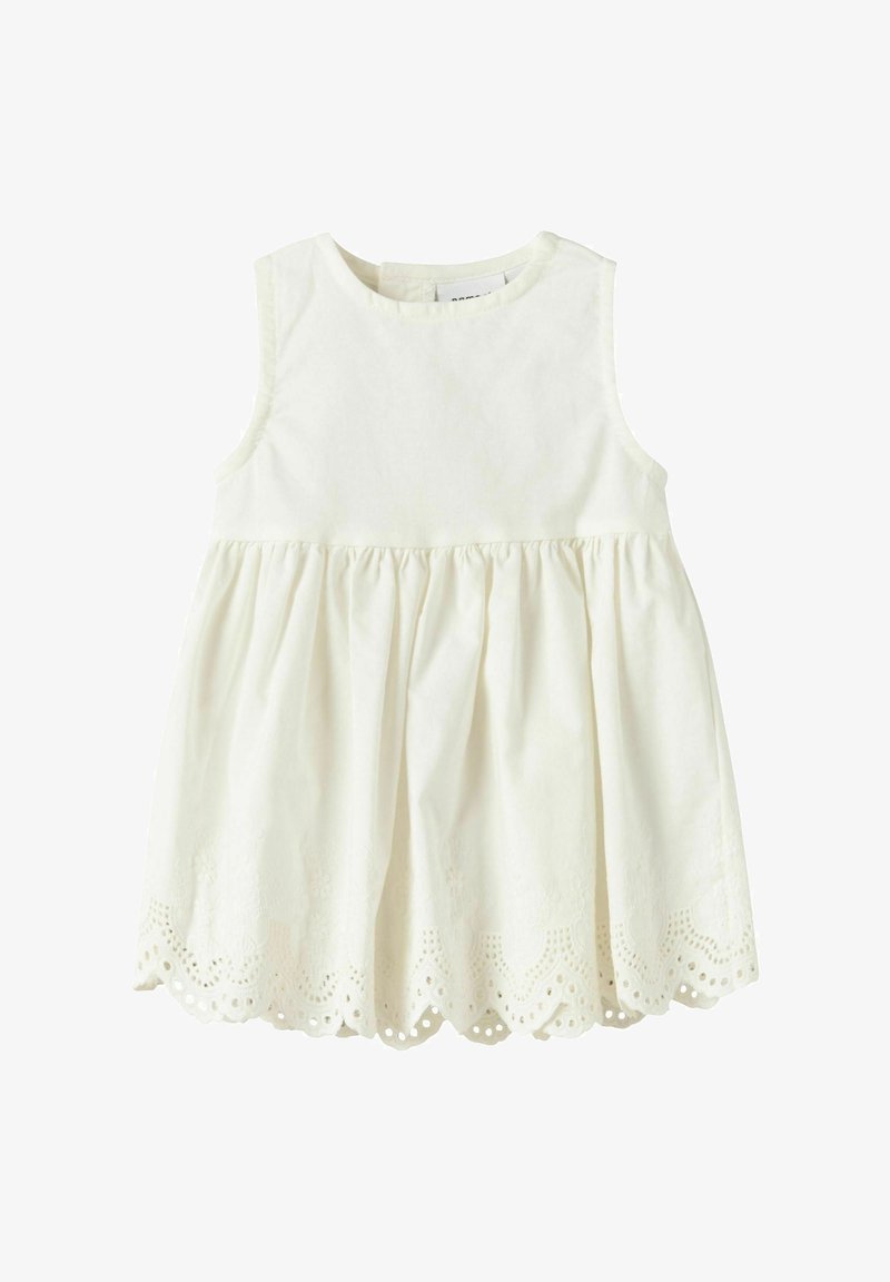 Robe bébé blanche sans manches avec taille froncée et ourlet festonné ornée de détails en dentelle ajourée.