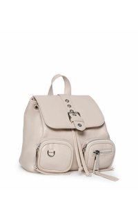 Jasnobeżowy skórzany plecak z klapą, z przednim zapięciem na klamrę, dwoma kieszeniami na zamek oraz dwoma kieszeniami bocznymi. Posiada regulowane ramiączka.