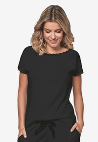 Czarny top z krótkim rękawem z koronkowym wykończeniem wzdłuż dekoltu i rękawów. Luźny krój, gładki materiał i subtelny design bez ozdób.