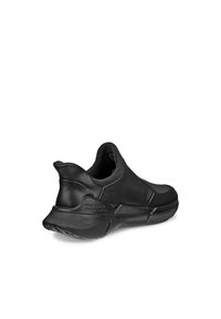 Sneaker nera slip-on realizzata in materiale liscio e flessibile con tacco arrotondato e suola testurizzata. Presenta un design minimalista senza lacci visibili.