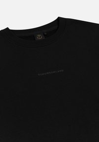 Zwarte sweatshirt van katoen met een geribde ronde hals. Voorzien van een subtiel bedrukte logo "TOMORROWLAND" op de voorkant. Over het algemeen een gladde textuur.