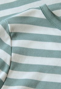 Groen en wit gestreepte katoenen stof met een zachte textuur; heeft een ronde halslijn en korte mouwen.