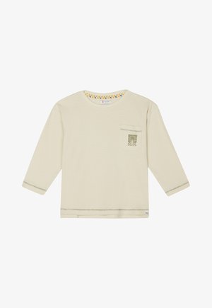 Długi rękaw kremowy top wykonany z miękkiego materiału, z kieszonką na piersi z zielonym wzorem palmy oraz kolorowymi paskami wokół dekoltu.