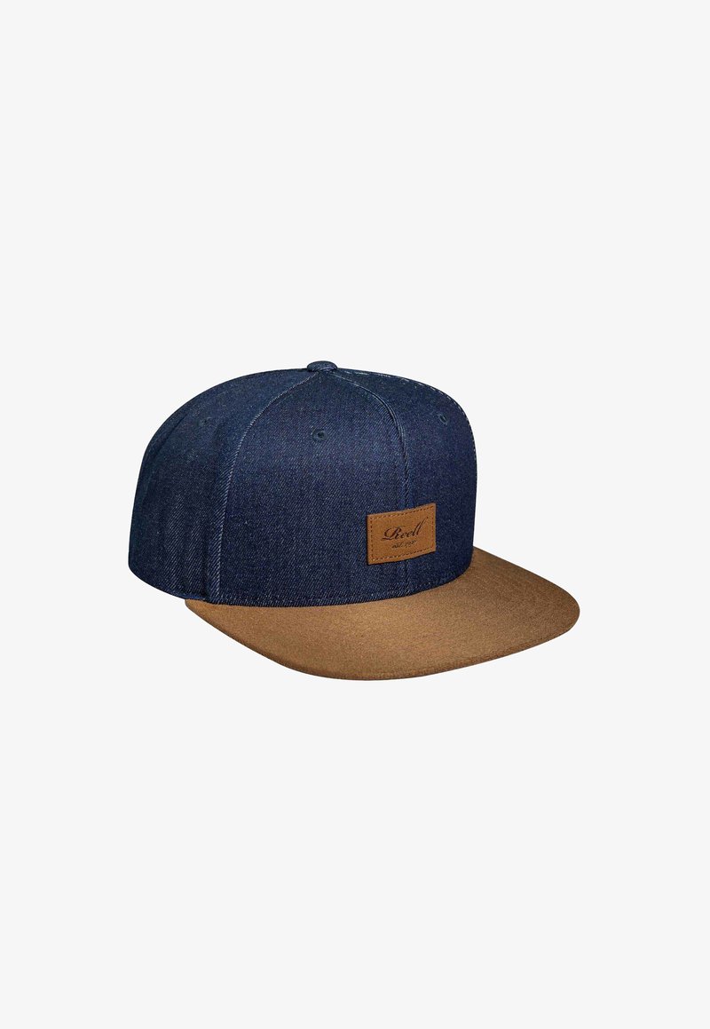 Gorra de denim con una corona azul oscura y visera plana de color marrón claro. Presenta un parche de cuero marrón con texto en la parte frontal.