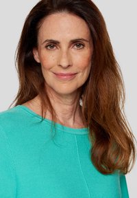 Aqua-farbenes Sweatshirt mit rundem Halsausschnitt und strukturiertem Strickmuster. Das Modell hat lange braune Haare und einen neutralen Hintergrund.