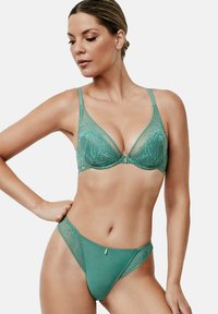 Ensemble de lingerie en dentelle turquoise, comprenant un soutien-gorge triangle avec des bretelles réglables et un string assorti avec de délicats motifs floraux et des accents subtils.