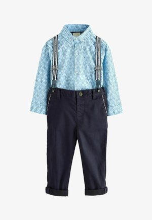 Lichtblauw gestreept overhemd met lange mouwen en kraag met knopen, en marineblauwe broek met opgerolde manchetten en verstelbare bretels.