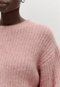 Hellrosanes, gestricktes Sweater mit strukturiertem, geripptem Design. Verfügt über einen runden Ausschnitt und einen weichen, flauschigen Stoff.