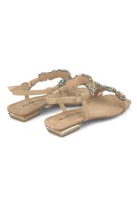 Sandali in suede beige con tacco basso, caratterizzati da accenti di cristallo scintillanti e un design della fascia testurizzato. Punta anteriore corta e appuntita.