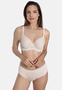 Beige gefütterter BH mit glatten Cups, verstellbaren Trägern und einer kleinen Schleifendetail in der Mitte. Kombiniert mit schlichten beigen High-Waist-Slips.