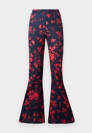 Flaresbukser i marineblåt stoff med et klart rødt blomsterdesign. Har en tilpasset midje og klokkeformede ben. Jevn tekstur.
