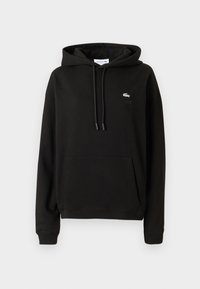 Čierna mikina Lacoste s predným vreckom, kapucňou na šnúrku, rebrovanými manžetami a malým vyšitým logo krokodíla na ľavej hrudi.