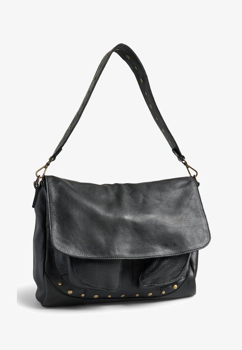 Sac d'épaule en cuir noir avec fermeture à rabat, bandoulière réglable avec clous métalliques et rivets décoratifs en laiton le long du bord inférieur.