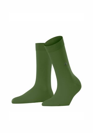 Zwei Paare von einfarbigen grünen Socken, die aufrecht stehen, mit gerippten Bündchen und einem kleinen Logodetail auf einer Seite.