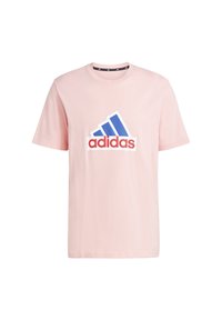 Rosa Baumwoll-T-Shirt mit einem großen blauen und roten Adidas-Logo in diagonalem Muster. Kurzärmlig, mit Rundhalsausschnitt.