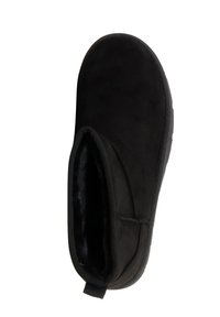 Scarpa slip-on in pelle scamosciata nera con interno morbido simile a pelliccia, punta arrotondata e linguetta ad anello sul retro per indossarla facilmente.