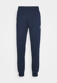 Mörkblå sweatpants i mjukt tyg, med tapered ben, elastisk midja och liten vit logotyp på sidan.