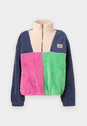 Flis jakna z visokim ovratnikom, z zadrgo spredaj, mornarsko modrimi rokavi, krem barve zgornji del prsnega koša, roza levi sprednji panel in zeleni desni sprednji panel.