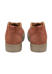 Botas de tobillo de ante marrón con un forro de felpa, puntera redonda y suela de goma beige. Presenta una pestaña de tirón y detalles de costura a lo largo de los lados.