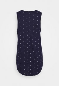 Haut sans manches bleu marine en tissu doux, avec un motif simple de petites formes géométriques blanches. L'ourlet arrondi met en valeur la silhouette.