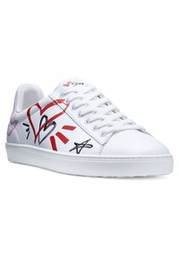 Baskets blanches avec une finition en cuir lisse, présentant des motifs graphiques colorés en rouge et noir, comprenant des coeurs et des étoiles, avec un système de laçage classique.