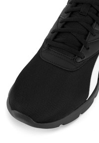 Čierna športová obuv s prednou časťou z sieťoviny, textúrovaným povrchom, plochými šnúrkami a bielym akcentom po strane, s gumovou podrážkou.