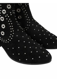 Bottines en daim noir avec des embellissements en clous argentés et des accents métalliques en forme d'engrenage sur les côtés.